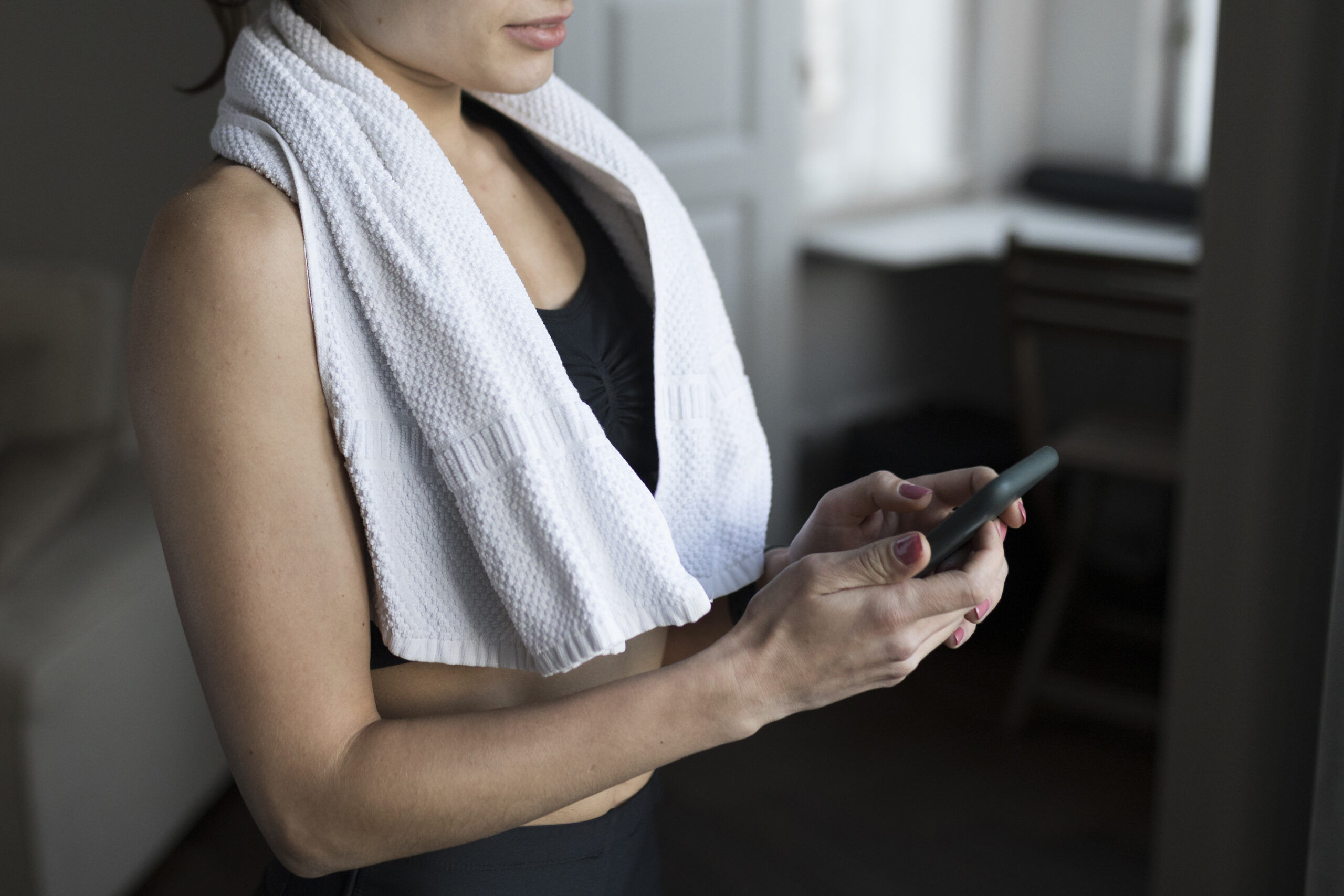 kobieta po treningu sprawdzająca telefon